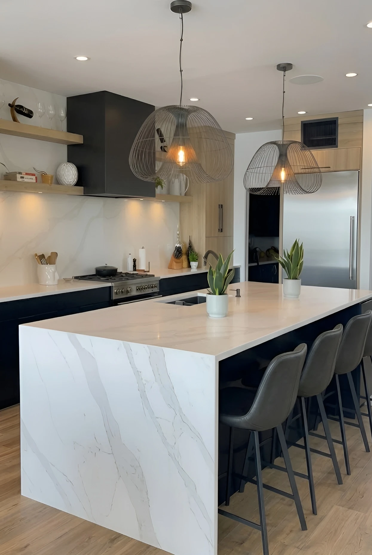 Modern kitchen with white quartz waterfall island, black cabinetry and wire pendant lights